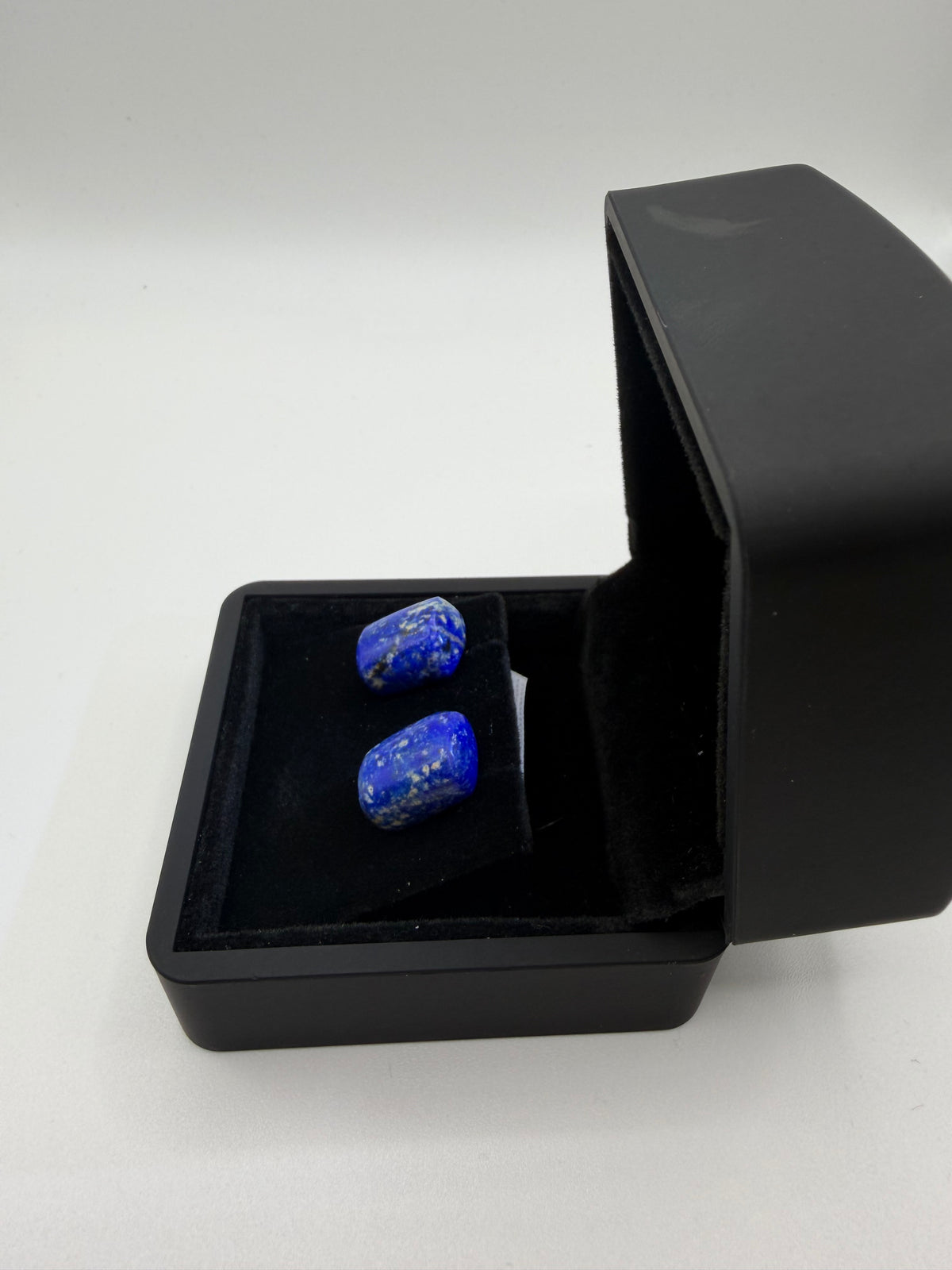 Side view of 26ct denim lapis lazuli stud earrings in black jewelry box — natural blue gemstone studs