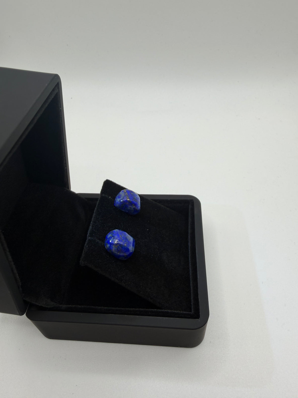 Side view of 13tcw lapis lazuli rectangular cabochon stud earrings in open black jewelry box, handcrafted in Maine