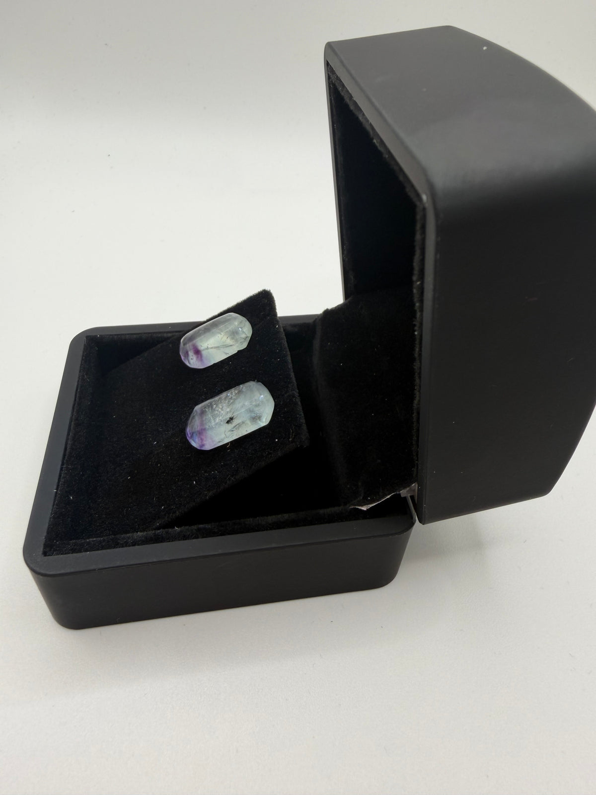 Side view of 16tcw Namibian fluorite rectangular barrel cabochon stud earrings in open black jewelry box