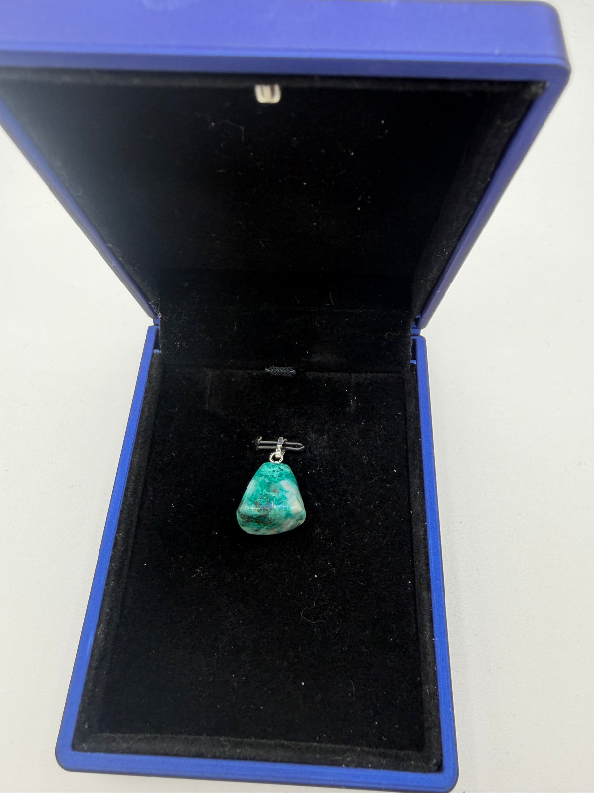Namibian Quantum Quattro pendant with teal-green and pale mineral patterns in a blue jewelry box.