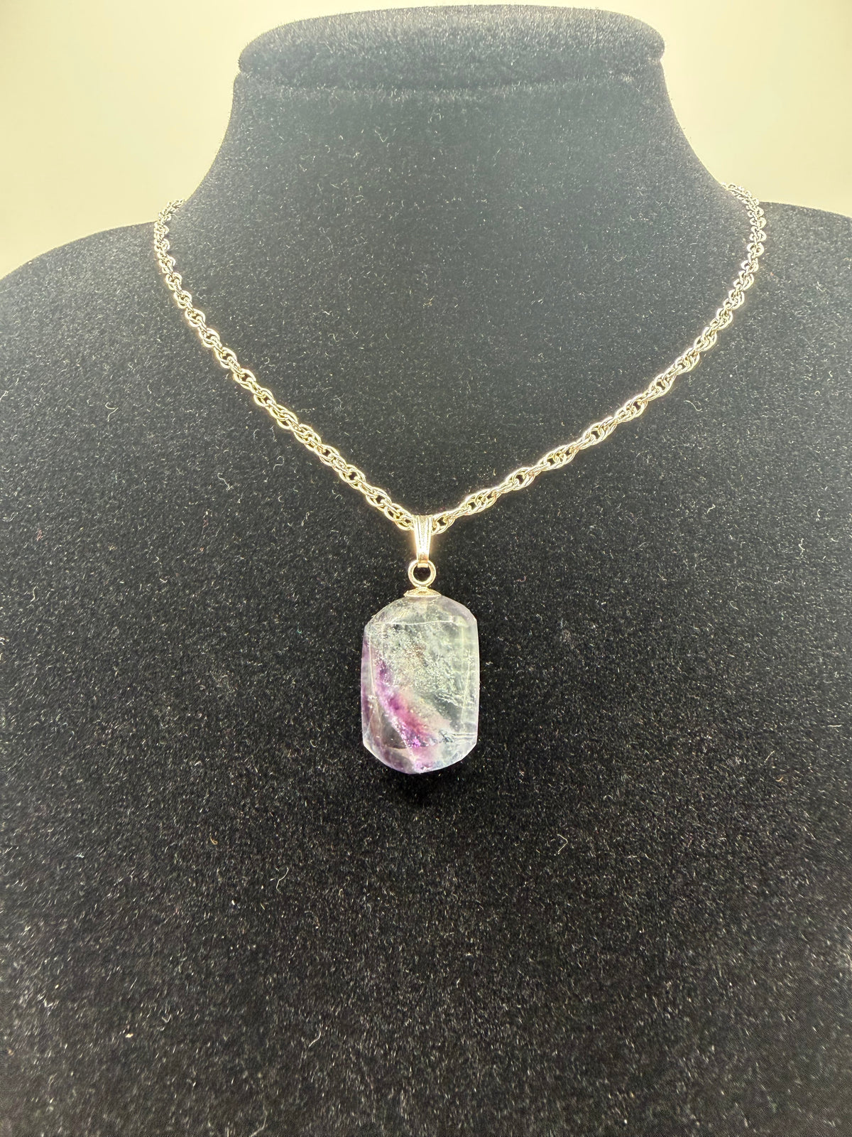 25ct Namibian fluorite pendant showing vivid violet-purple zoning and glassy clarity on a rope chain display, handcrafted in Maine