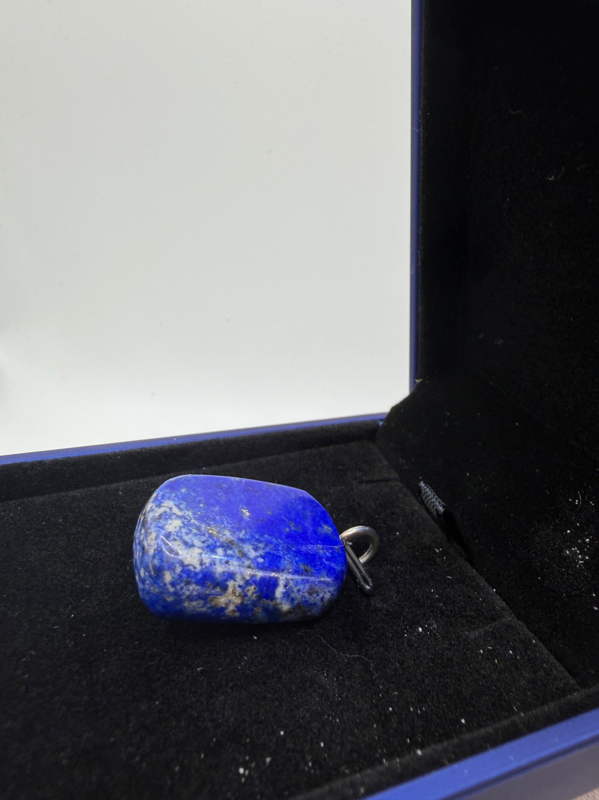 Top-down view of natural lapis lazuli cabochon pendant showing deep blue color and white calcite veining