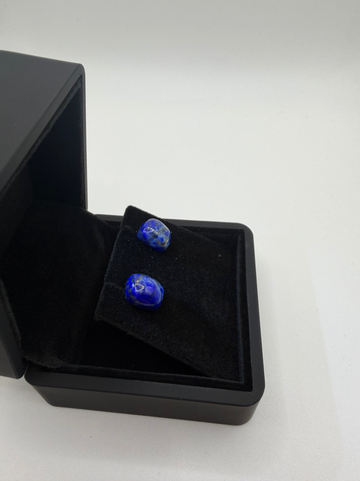 Side view of 11tcw lapis lazuli cushion cabochon stud earrings in open black jewelry box, handcrafted in Maine