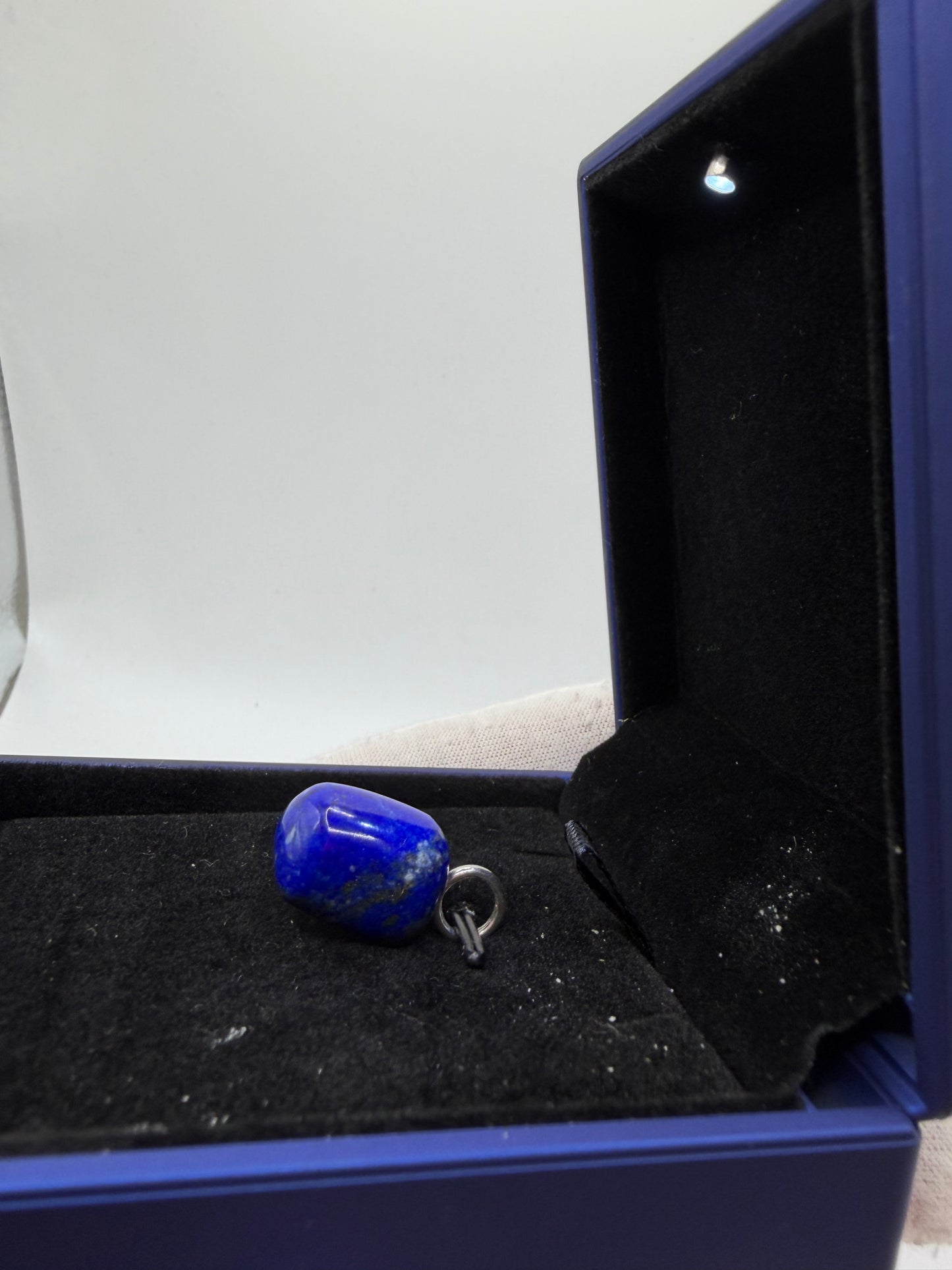 Side view of large natural Lapis Lazuli gemstone pendant with sterling silver bail — one-of-a-kind handcrafted jewelry