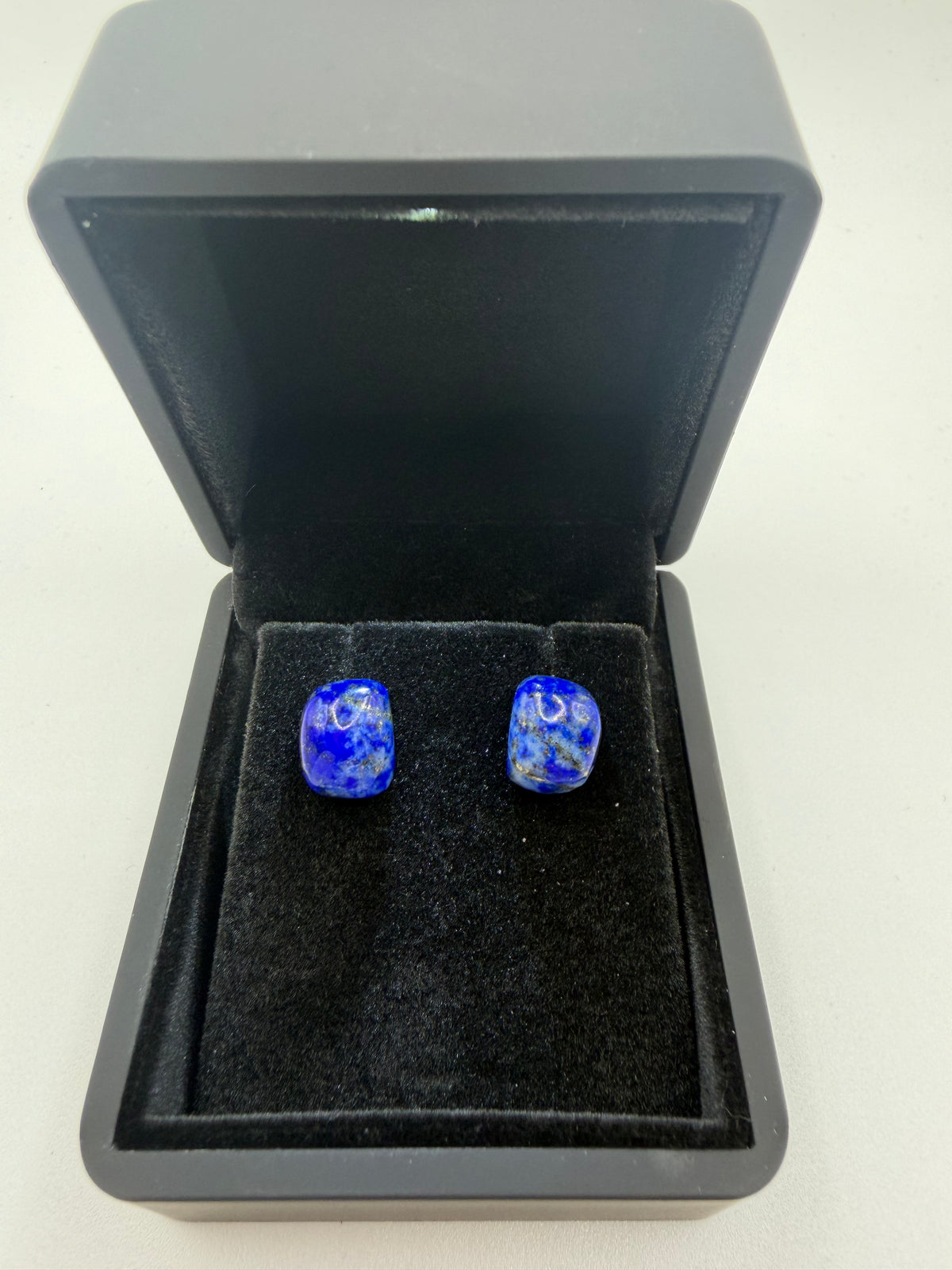 11tcw natural lapis lazuli cushion cabochon stud earrings in deep royal blue with pyrite flecks, displayed in open black jewelry box