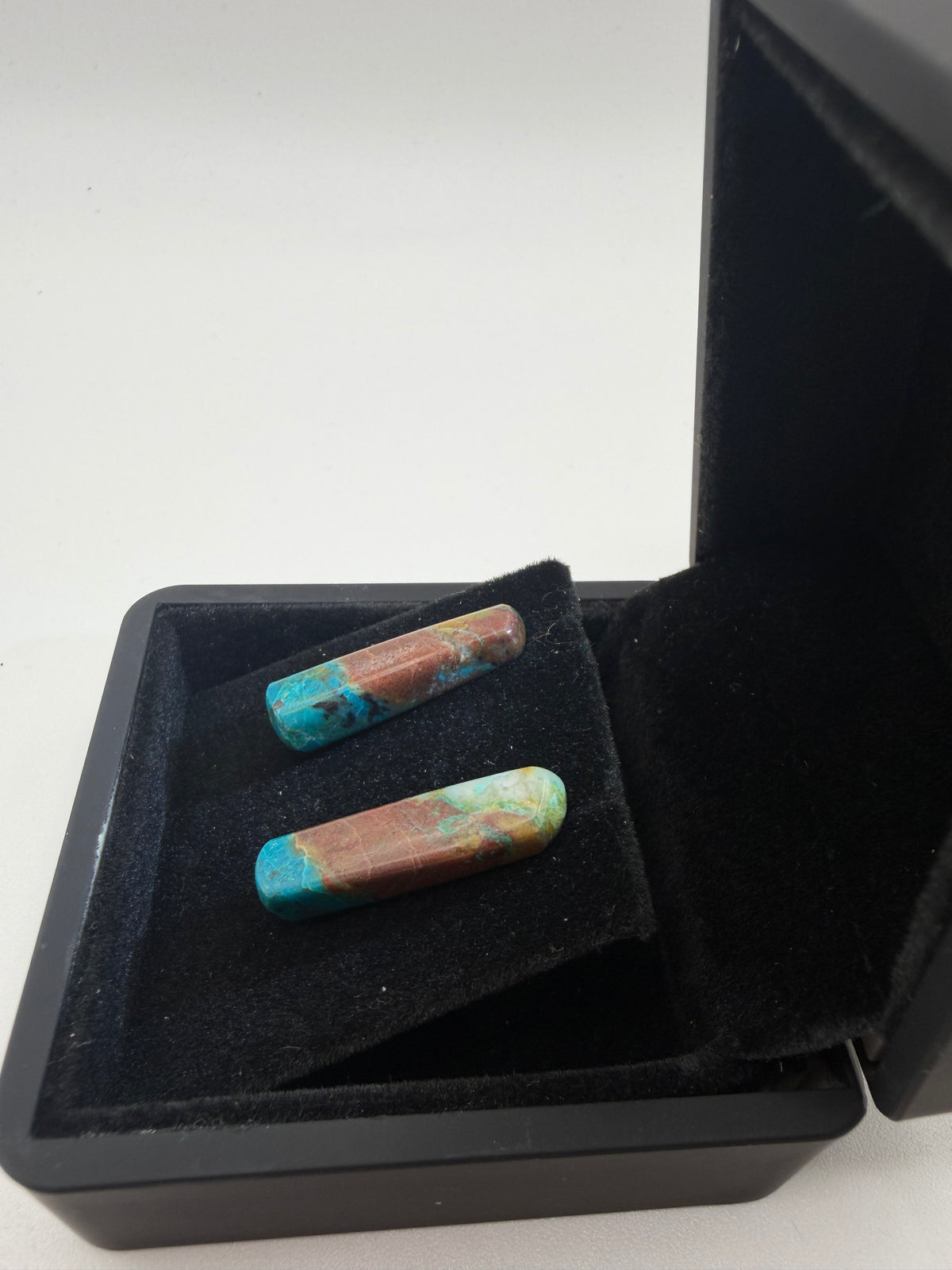 Side view of 18tcw Namibian Quantum Quattro elongated bar cabochon stud earrings in open black jewelry box, handcrafted in Maine