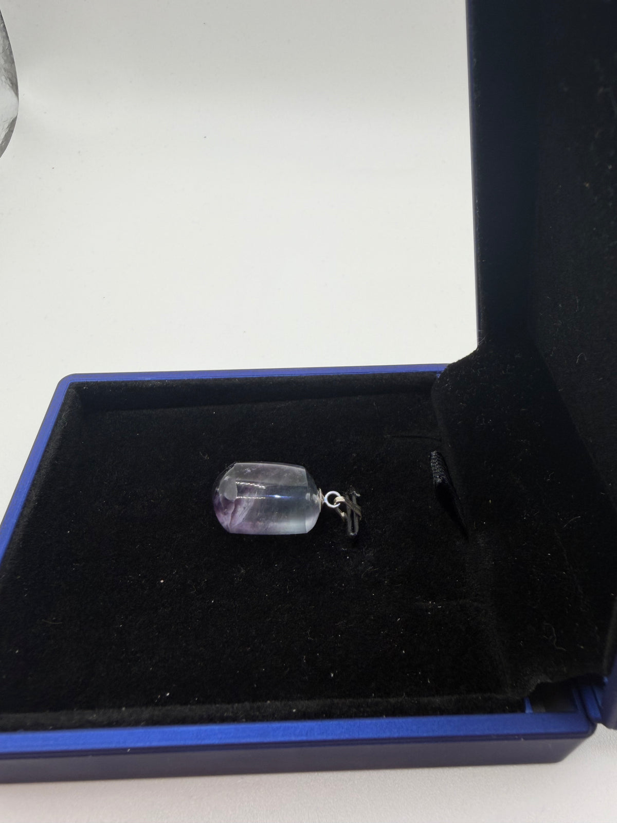 25ct natural Namibian fluorite pendant with near-colorless to violet-purple color zoning, sterling silver bail, in open blue jewelry box