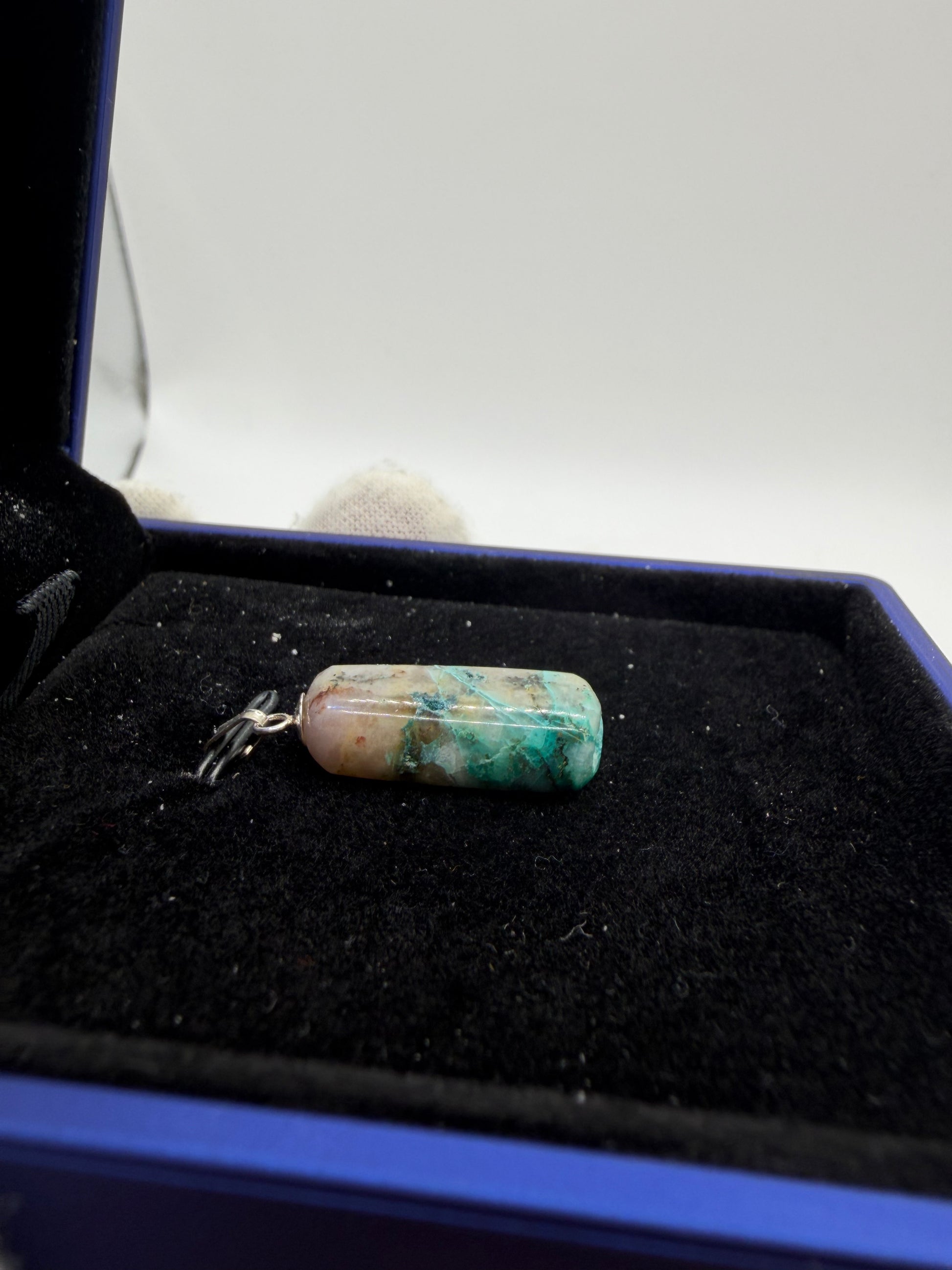 Side view of 15ct Namibian Quantum Quattro gemstone pendant showing natural blue-green mineral patterns and unique stone character