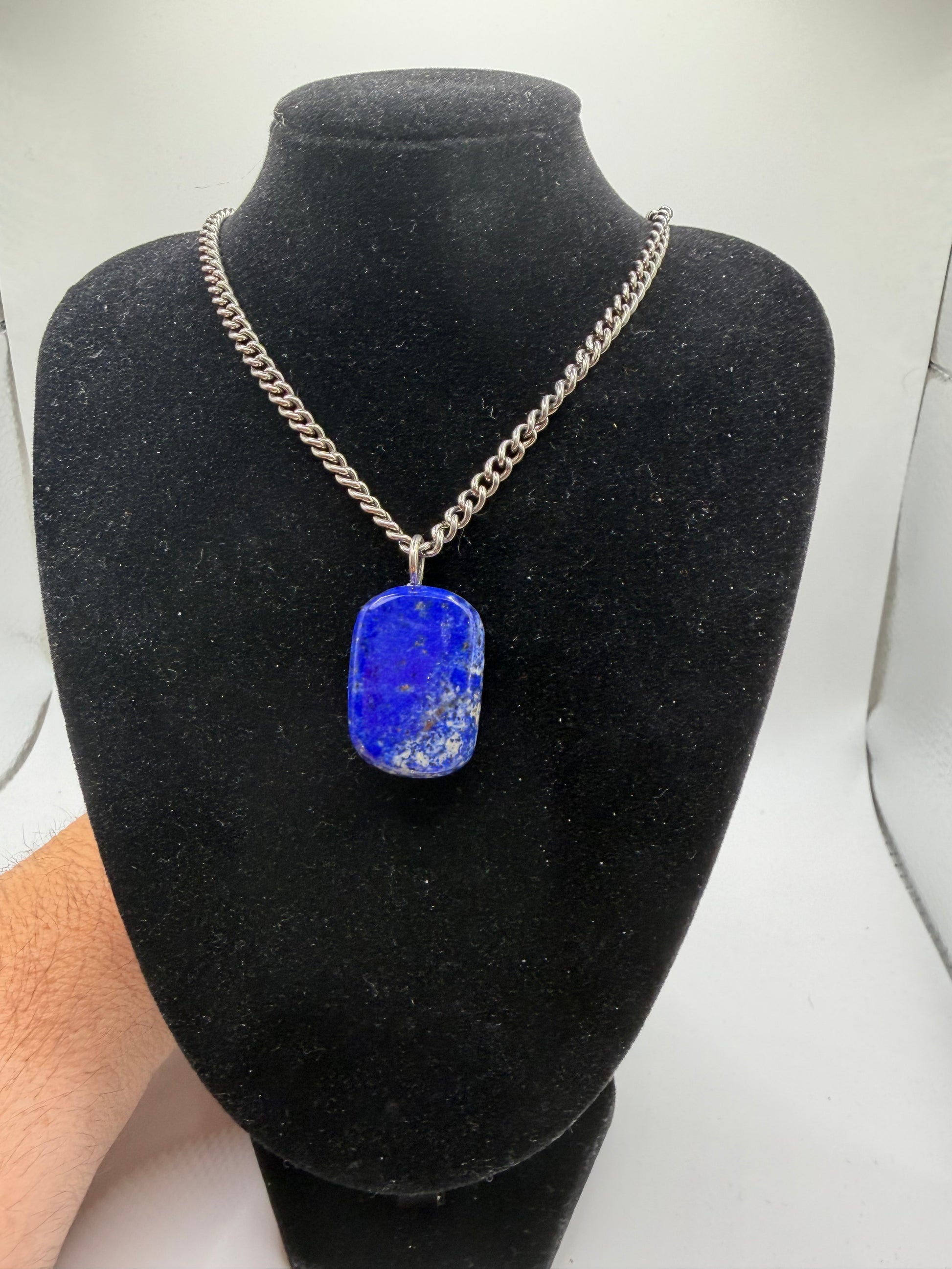 Natural lapis lazuli cabochon pendant on silver curb chain displayed on black jewelry bust