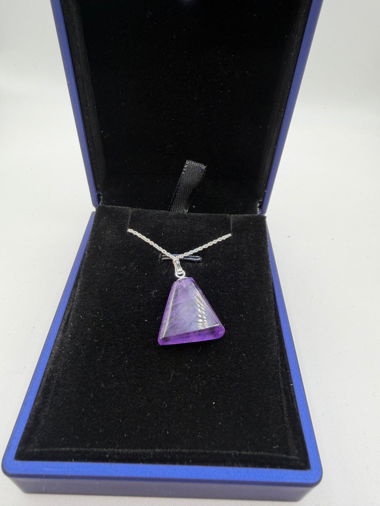 Close-up of 16ct natural Rwandan amethyst triangular cabochon showing deep purple color and clarity