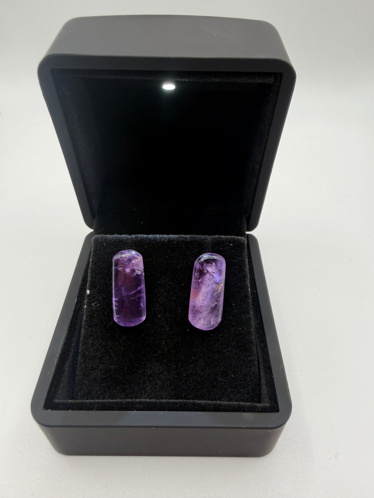 Front view of Rwandan amethyst bar stud earrings showing violet color and distinct natural internal patterns.