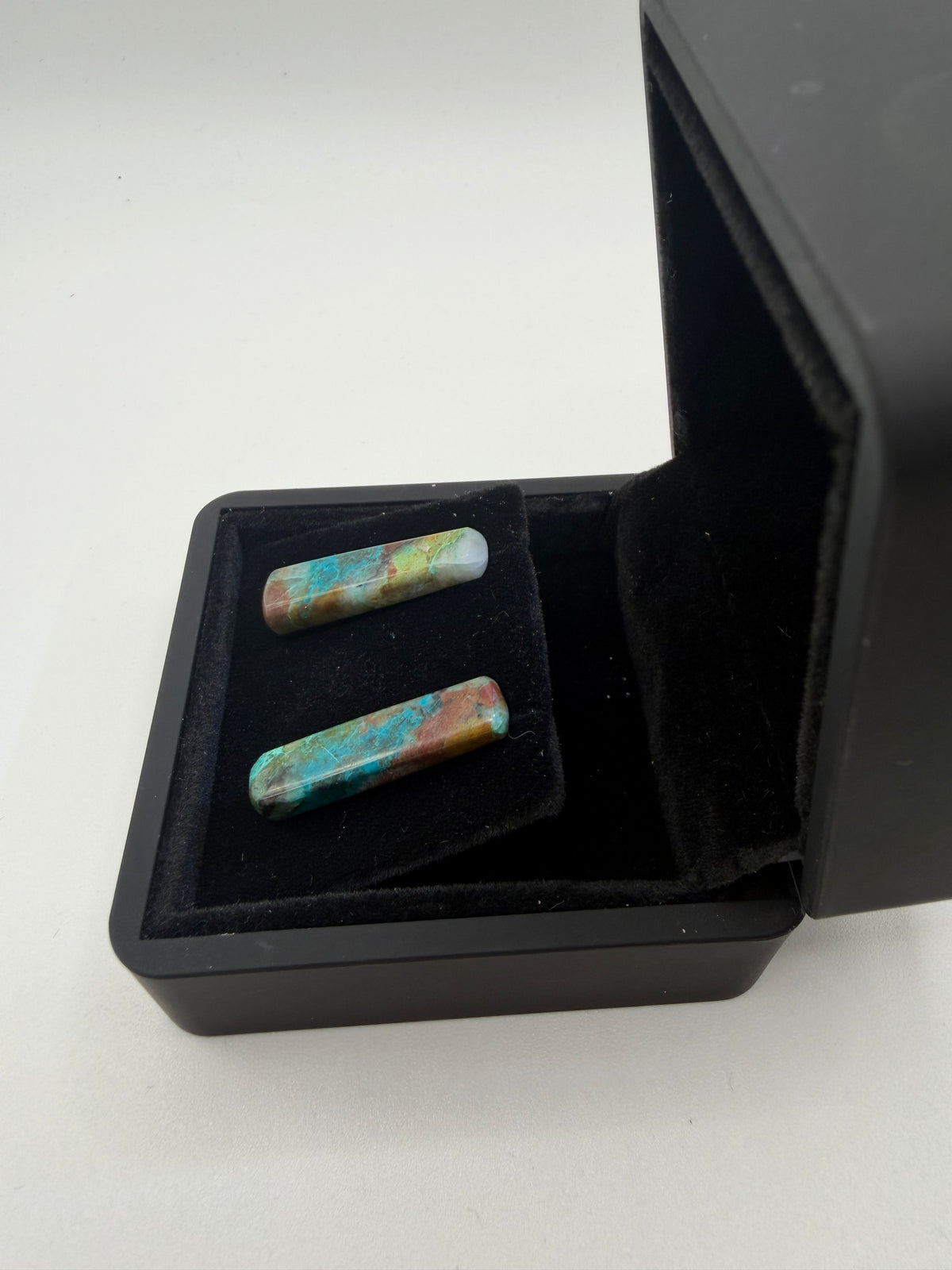 Side view of 18tcw Namibian Quantum Quattro bar cabochon stud earrings in open black jewelry box, handcrafted in Maine