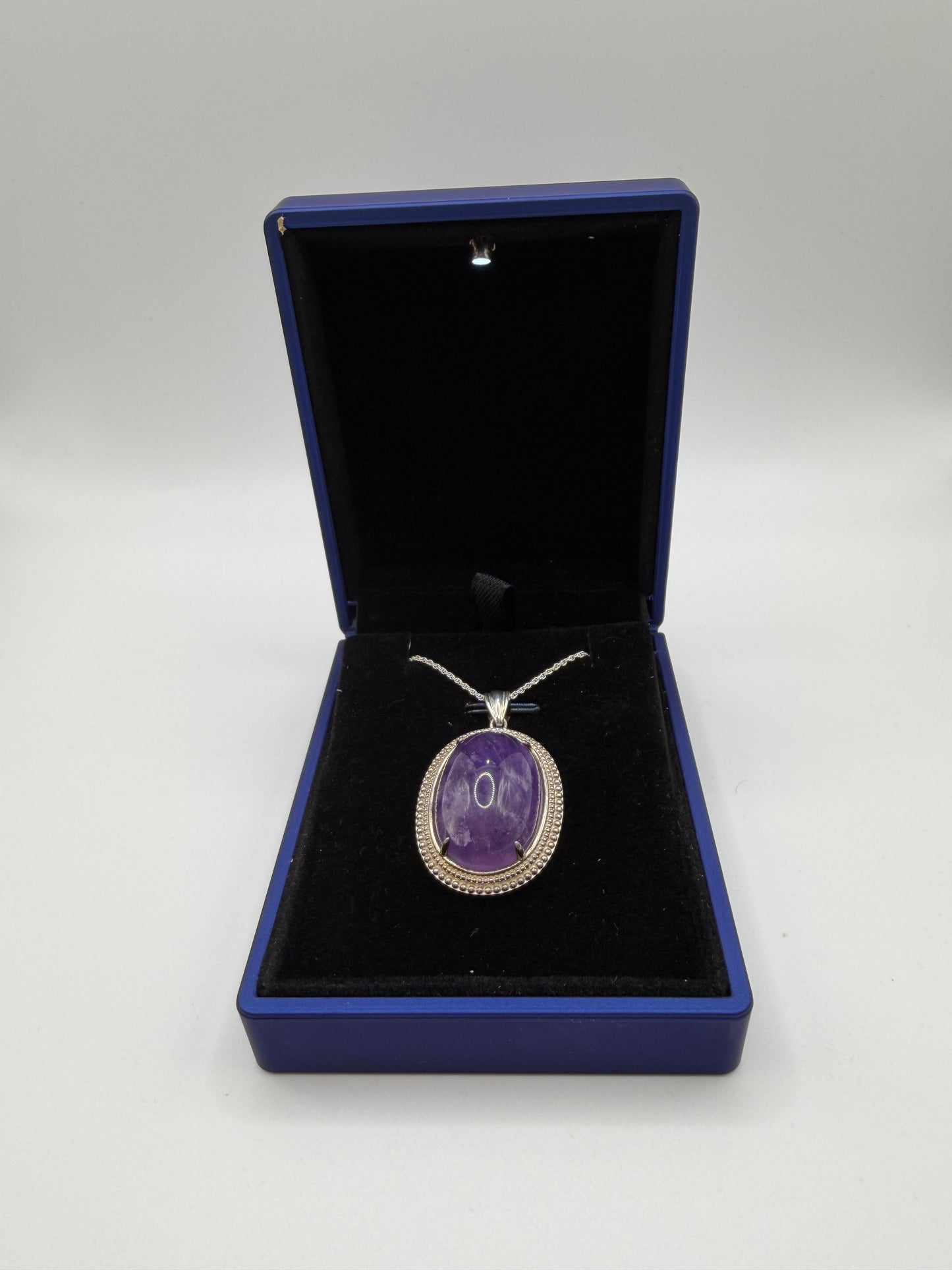 Close-up of natural Rwandan amethyst cabochon showing deep purple color and clarity