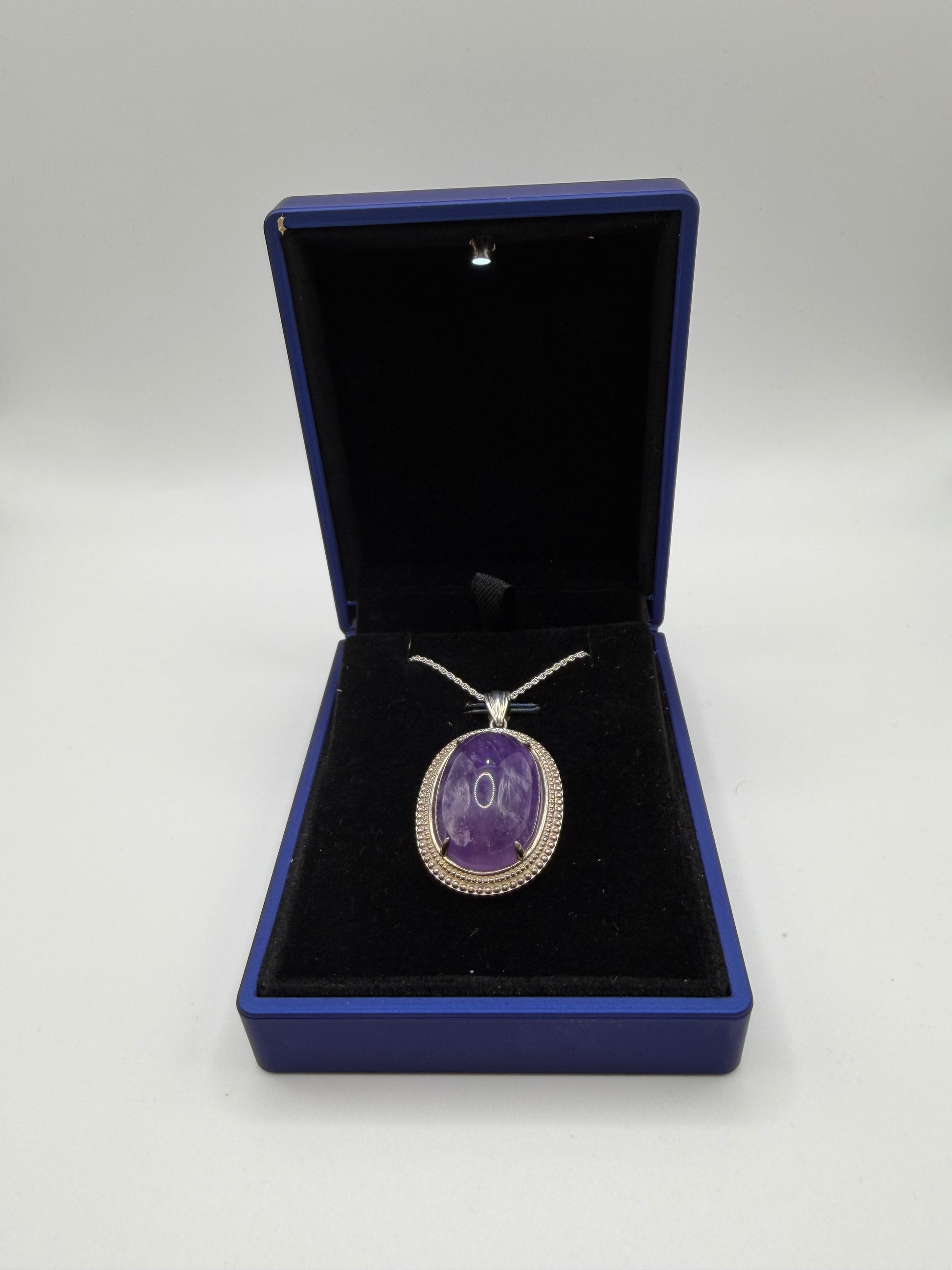 Close-up of natural Rwandan amethyst cabochon showing deep purple color and clarity