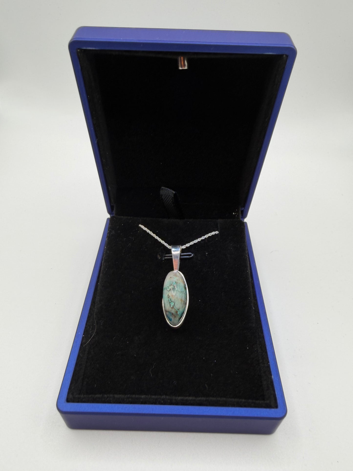 Close-up of slender oval Quantum Quattro cabochon from Namibia showing deep blue Shattuckite and green matrix patterns