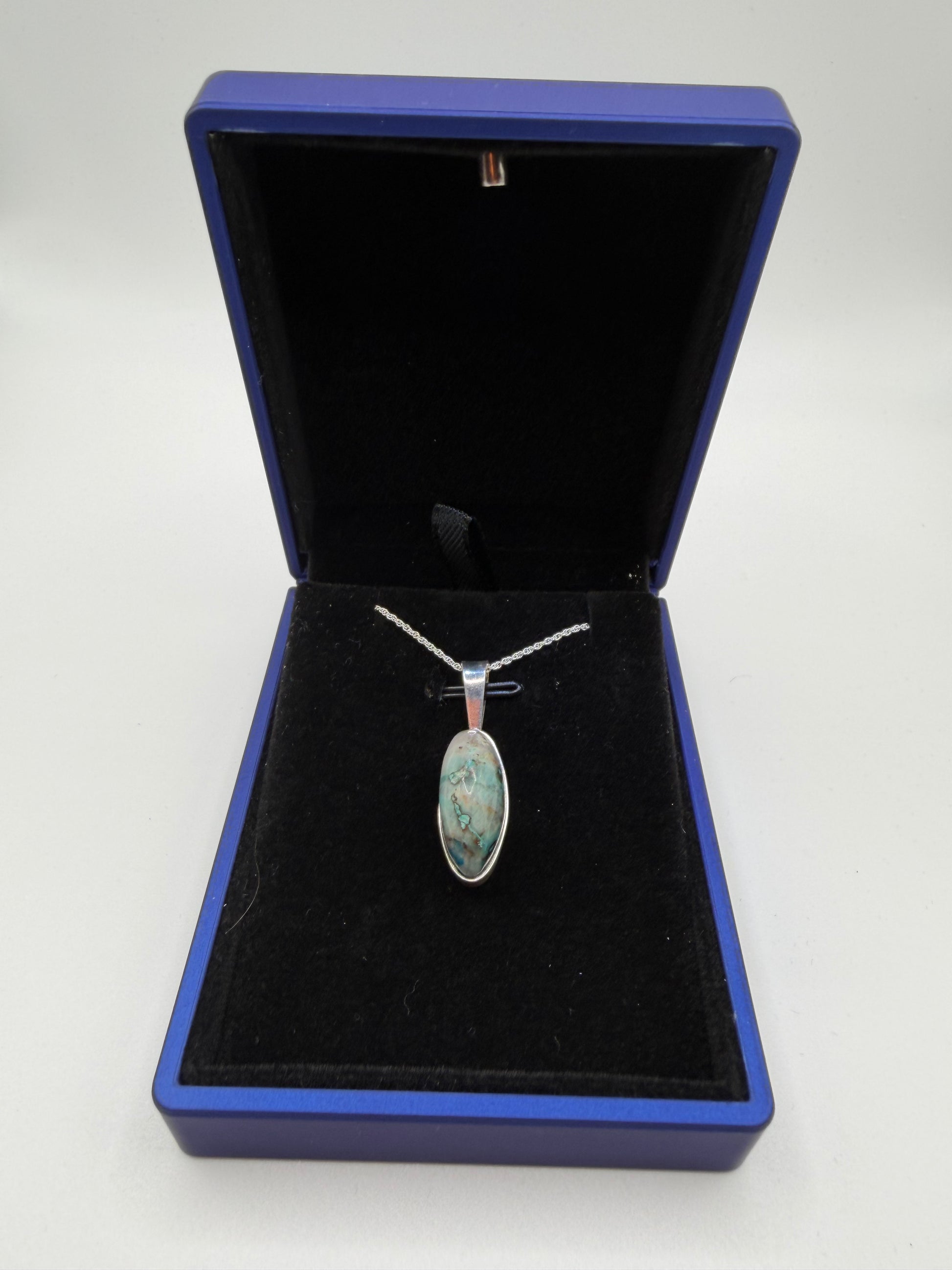 Close-up of slender oval Quantum Quattro cabochon from Namibia showing deep blue Shattuckite and green matrix patterns