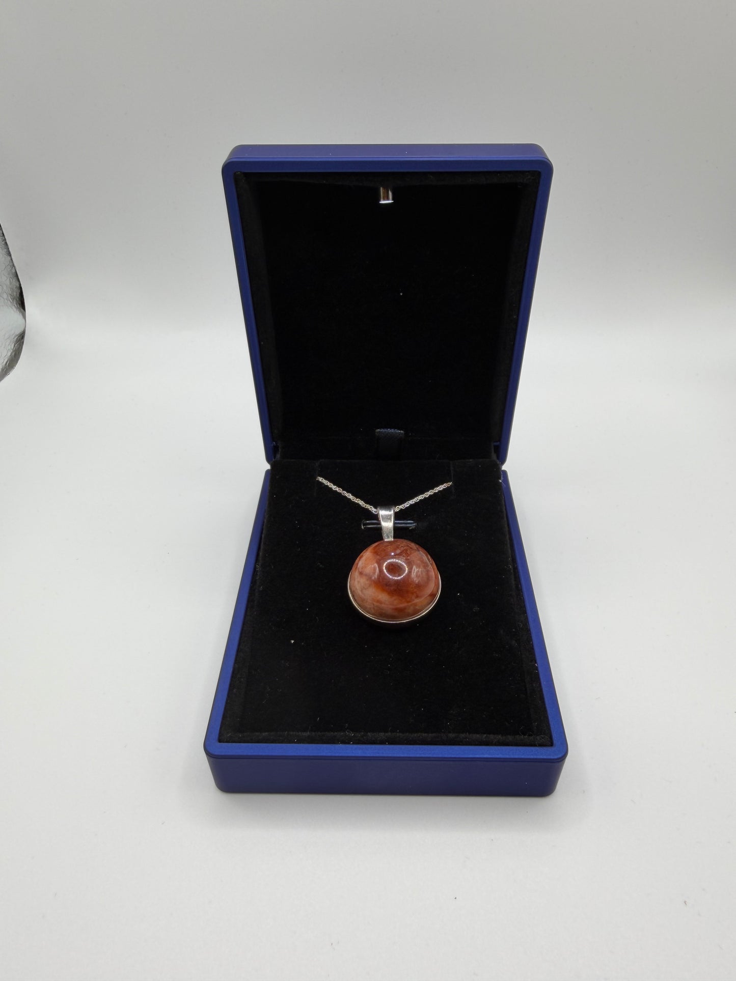 Close-up of 20mm translucent Hartland Carnelian cabochon showing warm brown-orange tones and natural iron-rich patterns