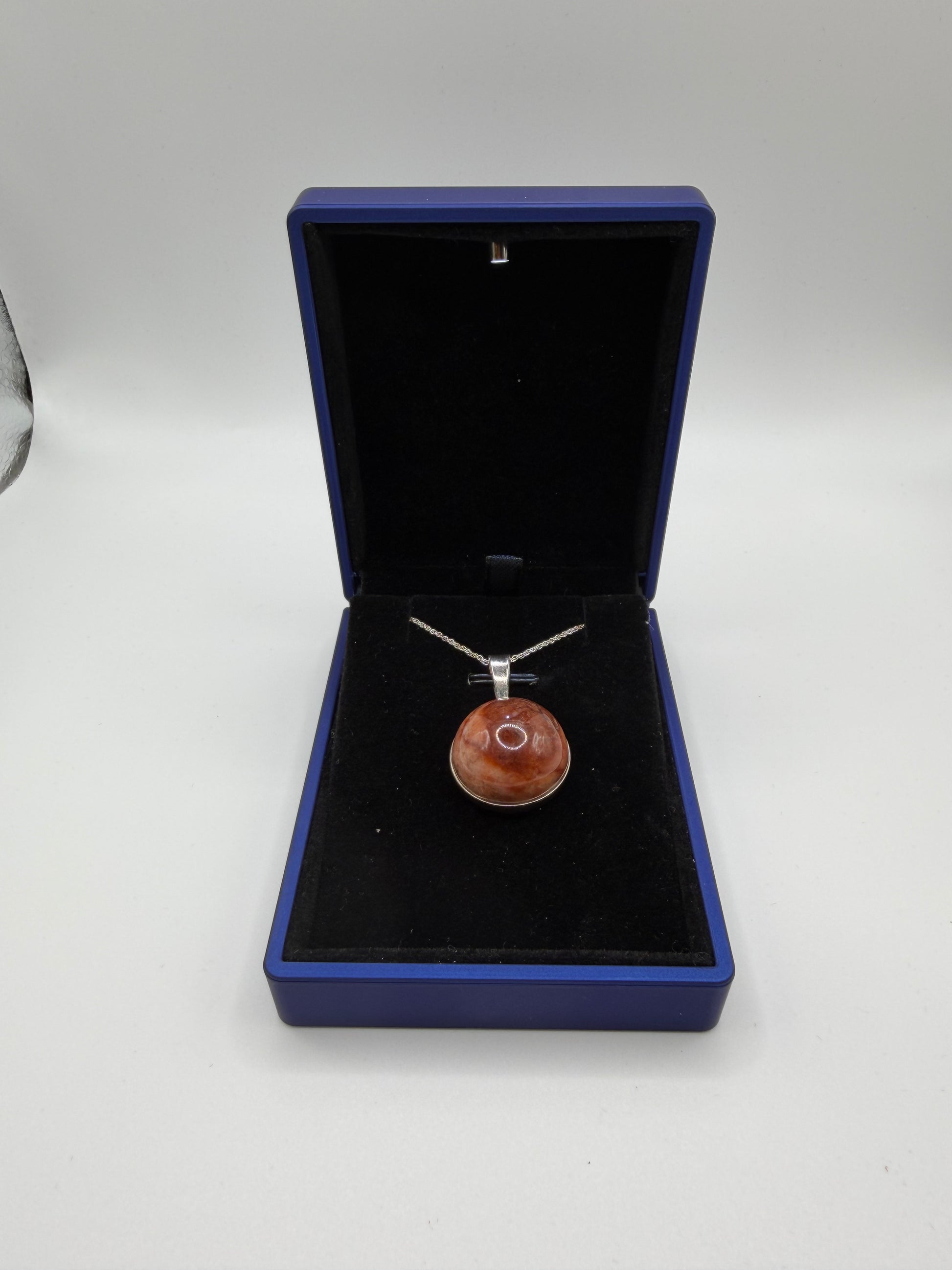 Close-up of 20mm translucent Hartland Carnelian cabochon showing warm brown-orange tones and natural iron-rich patterns