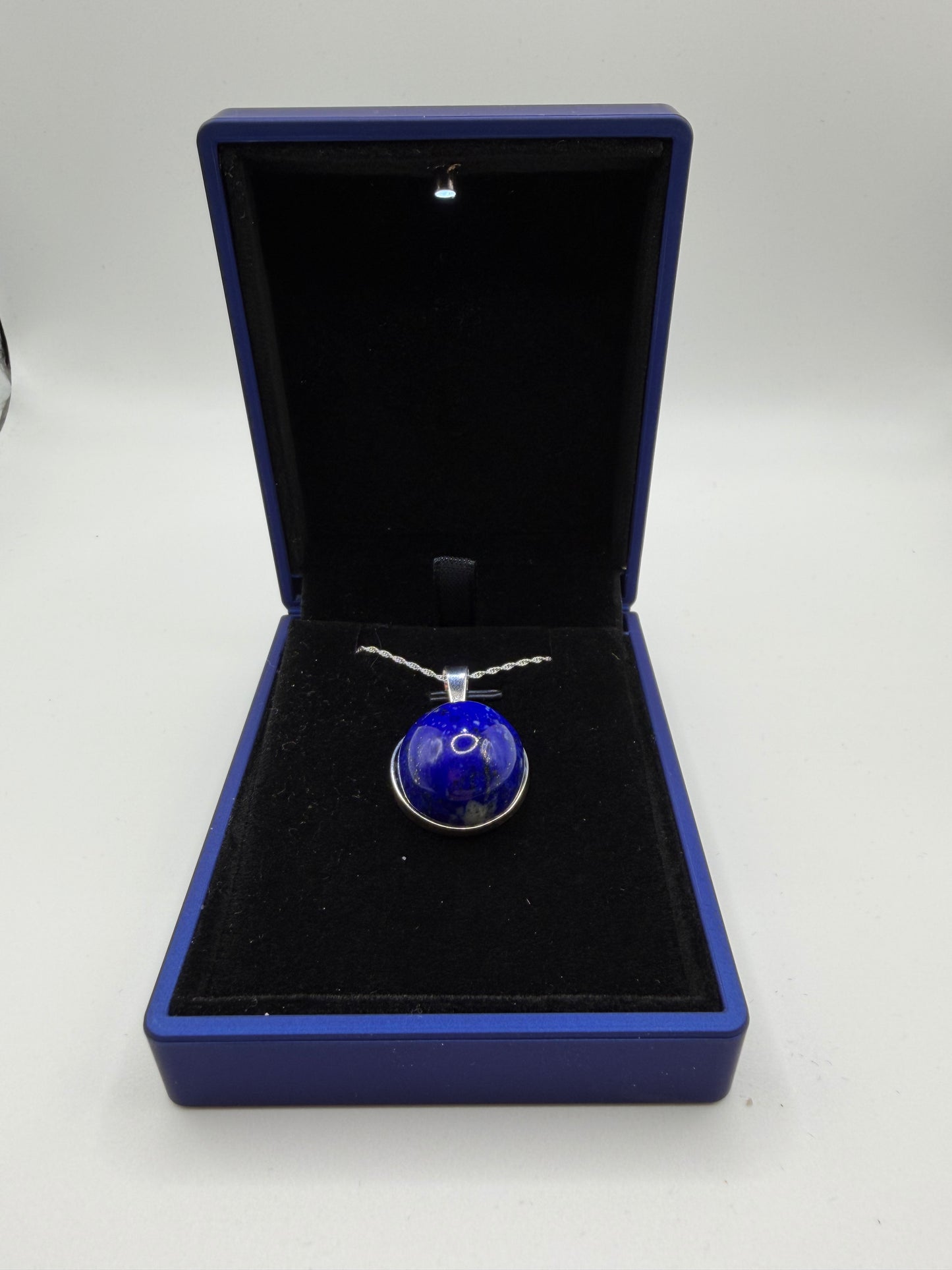 Close-up of 20mm natural lapis lazuli cabochon showing deep blue color and golden pyrite flecks