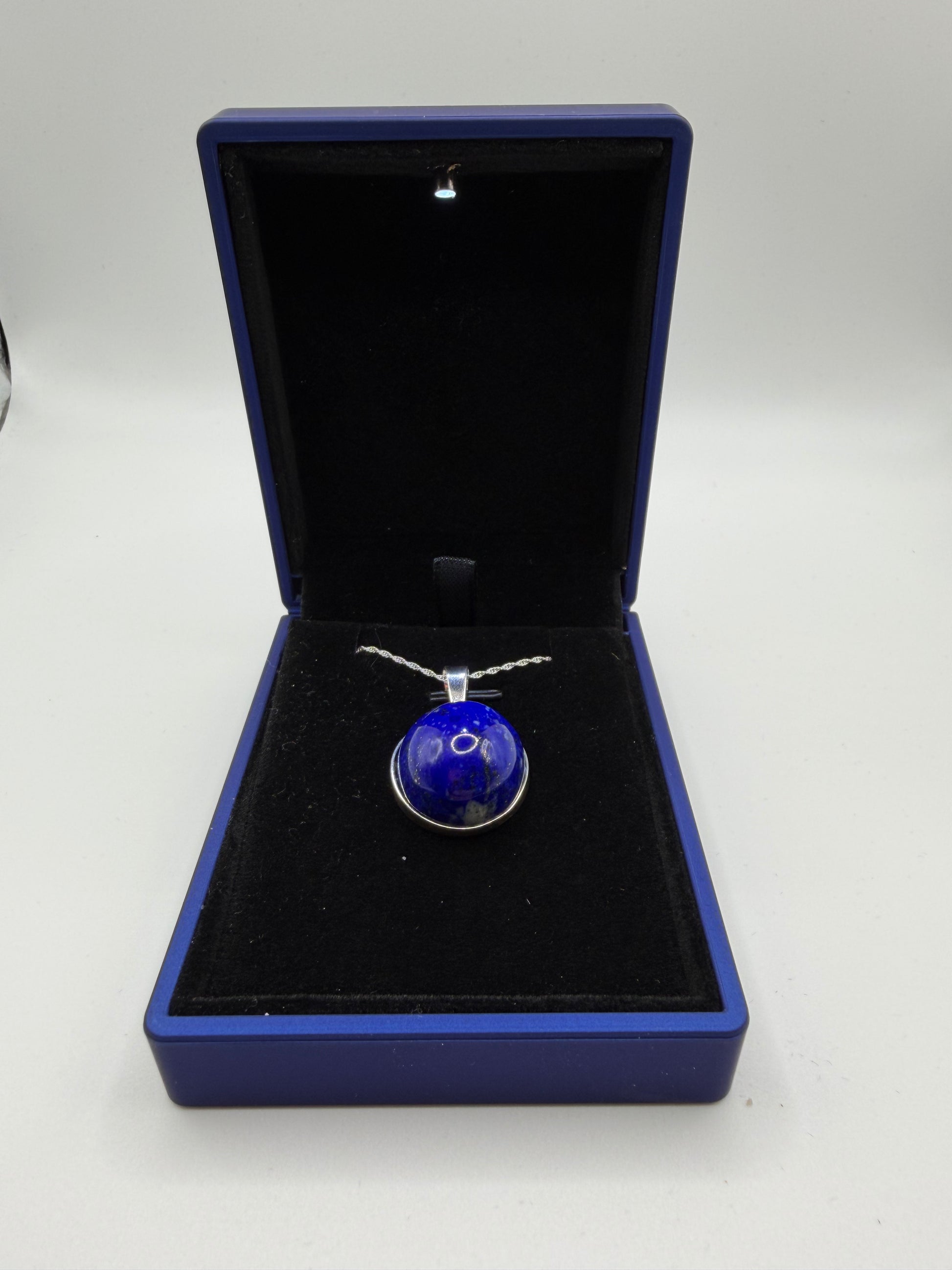 Close-up of 20mm natural lapis lazuli cabochon showing deep blue color and golden pyrite flecks