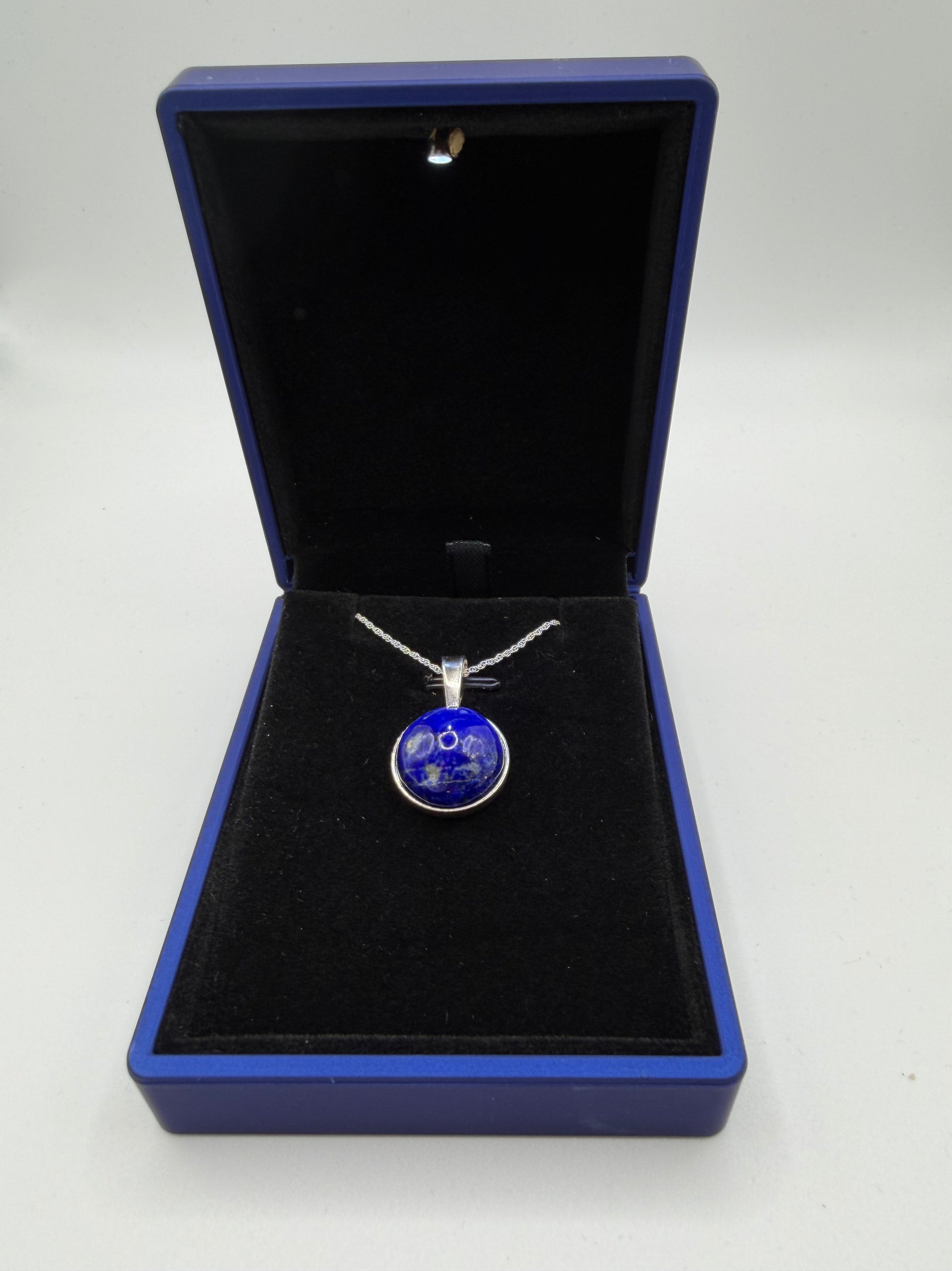 Close-up of deep blue lapis lazuli cabochon showing natural golden flecks and matrix