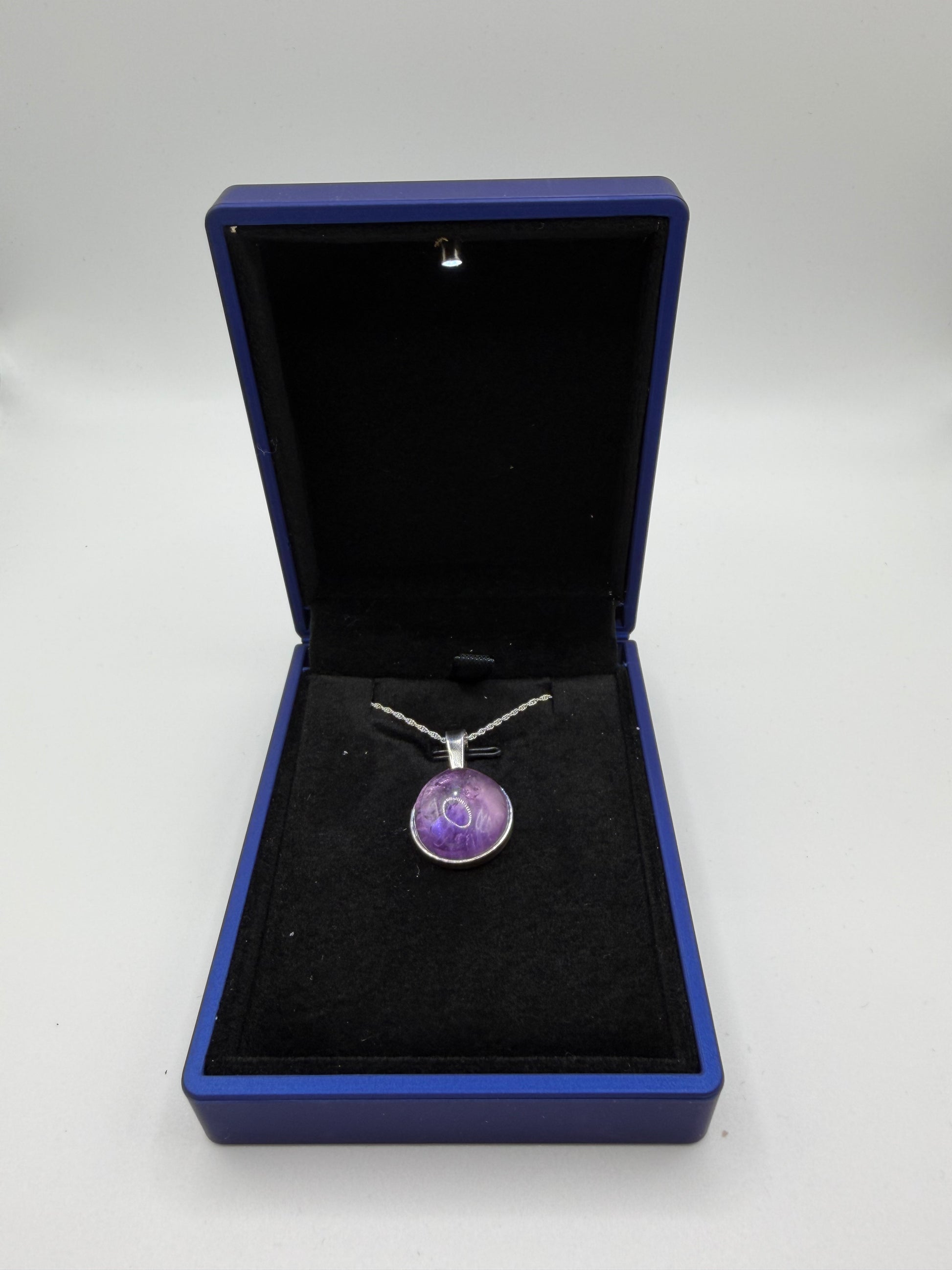 Close-up of 16mm Rose de France Rwandan Amethyst cabochon with soft lavender-rose tones and natural clarity