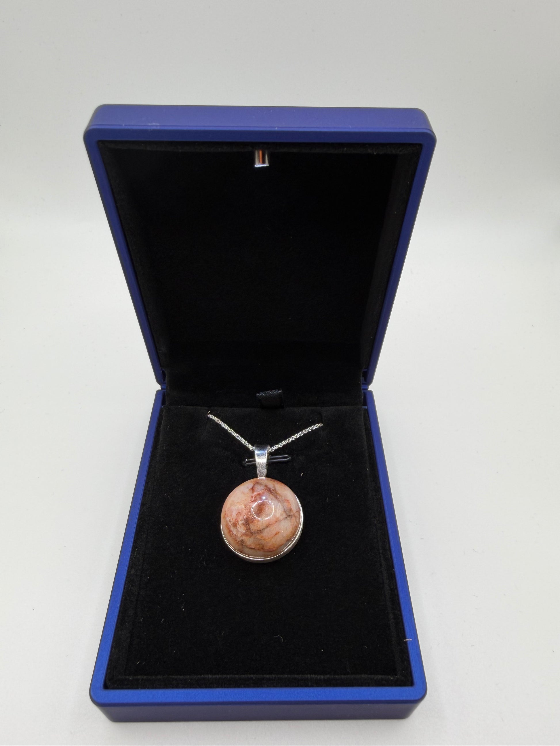 Close-up of translucent Hartland Carnelian cabochon showing warm brown-orange tones and natural iron-rich patterns